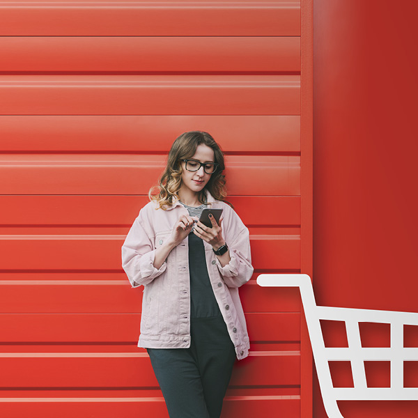 Woman leaning against garage door looking at mobile