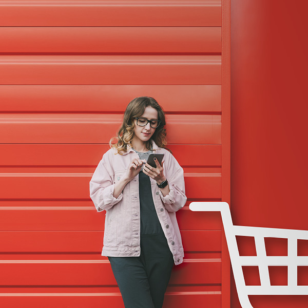 Woman leaning against garage door looking at mobile