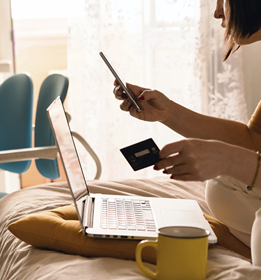 Woman looking at mobile, holding credit card