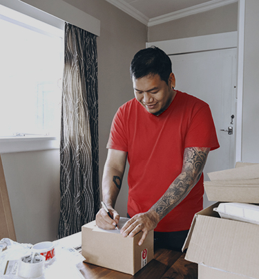 Man writing address on courier package