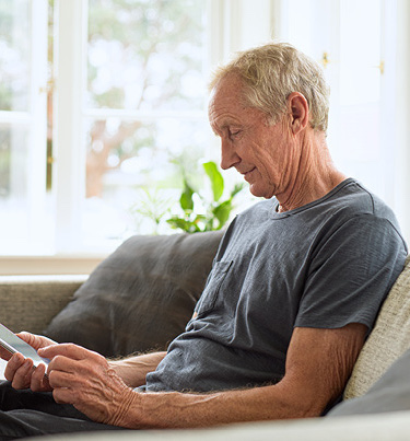 Man on couch looking down at mobile