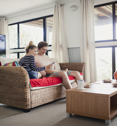 People on couch looking at mobile