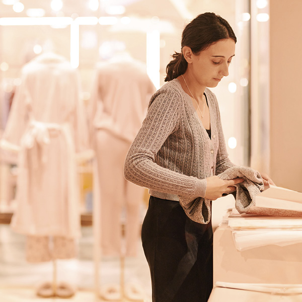 Woman in clothes shop packing item into bag