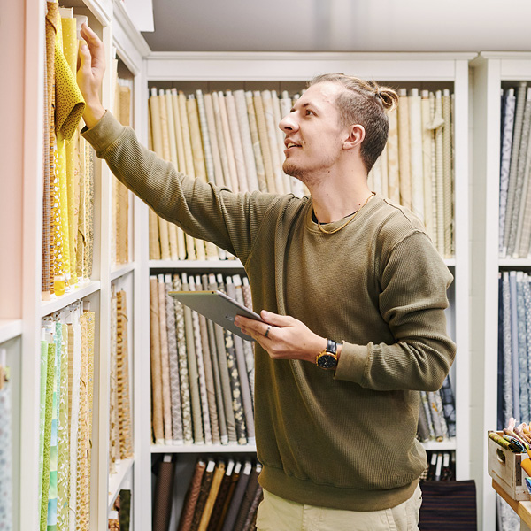 Man in material shop holding a tablet