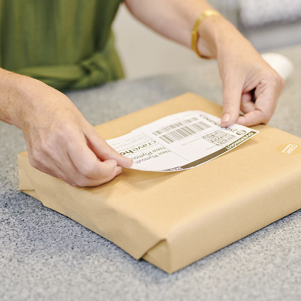 Woman putting courier label on package