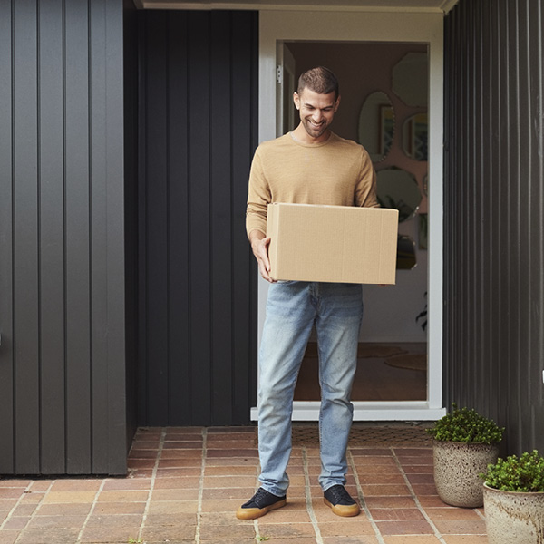 Man carrying courier pack outside his house