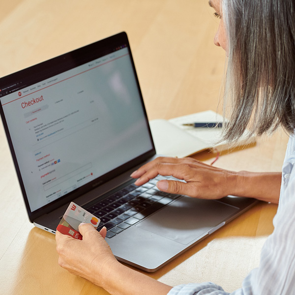 Woman shopping on laptop, holding credit card