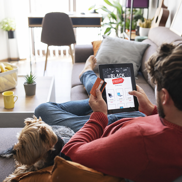 Man sitting down with tablet and credit card in hands 