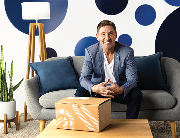 Man sitting on couch in front of courier package