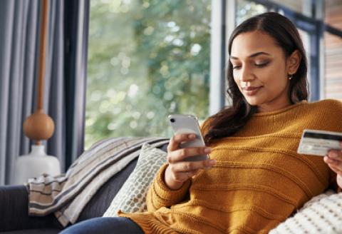 Woman holding credit card and phone