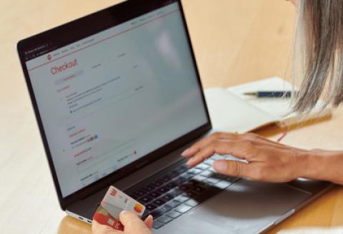 Woman shopping on laptop, holding credit card