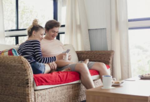 People on couch looking at mobile