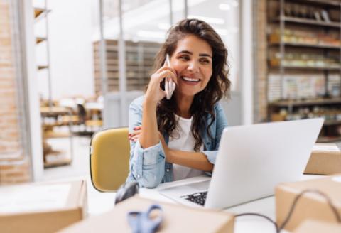 woman talking on her mobile in front of computer