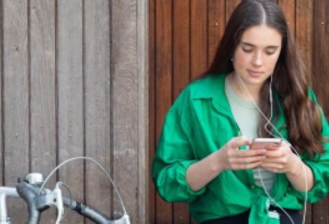 Girl looking at mobile, with headphones in her ears