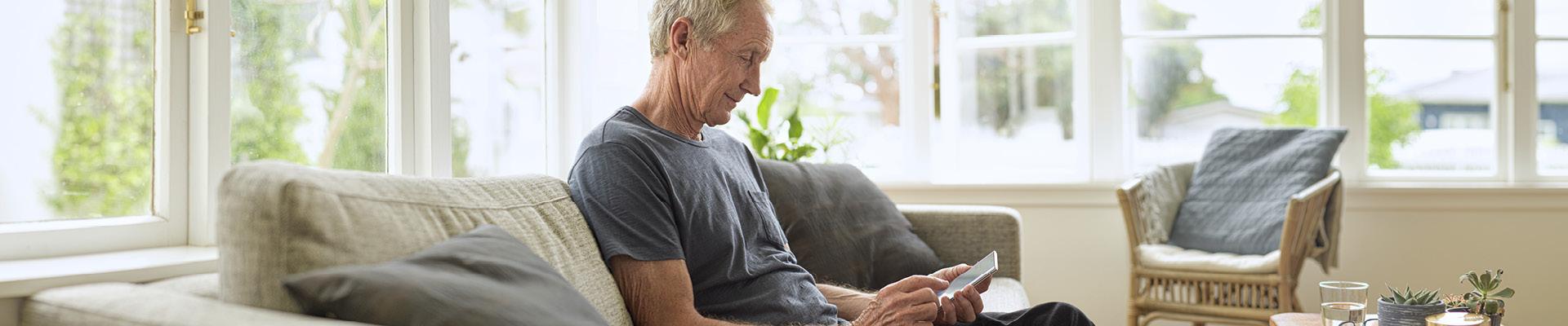 Gentleman sitting on couch using mobile phone 