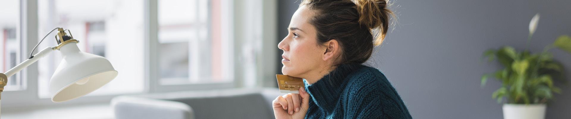 Woman in-front of laptop holding credit card