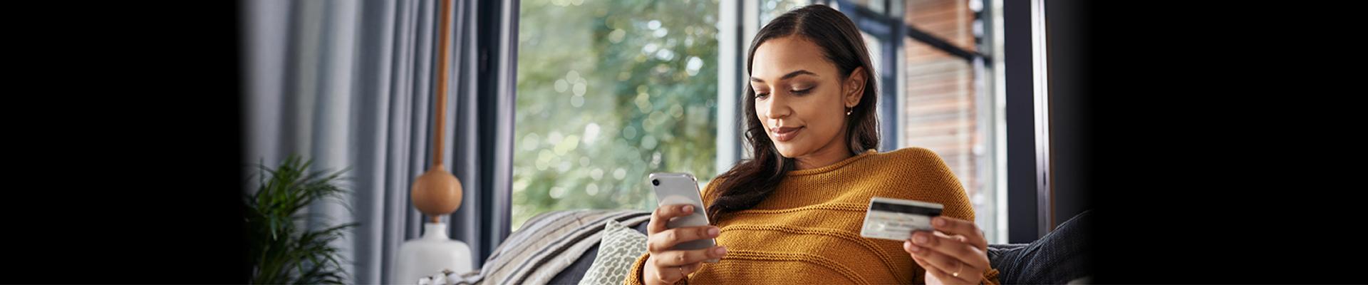 Woman holding credit card and phone