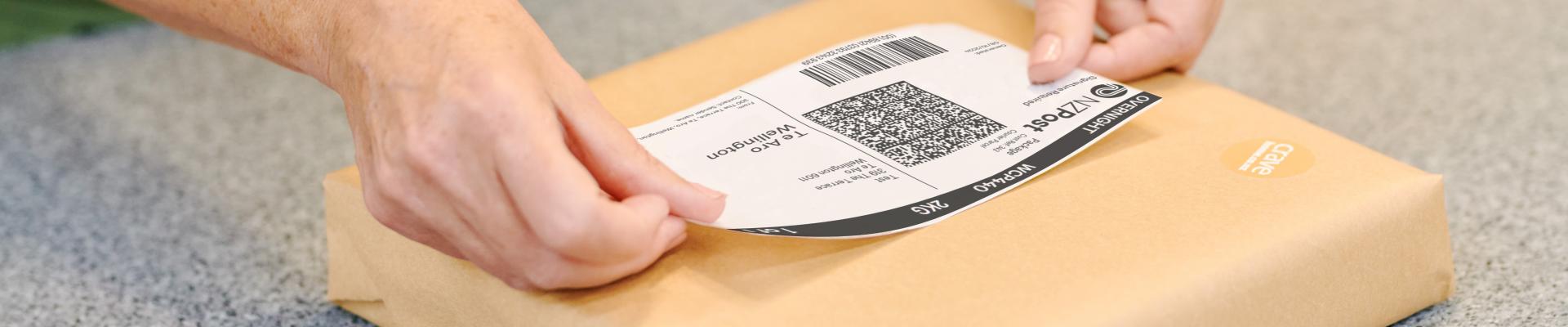 NZPost Label being applied to a brown parcel