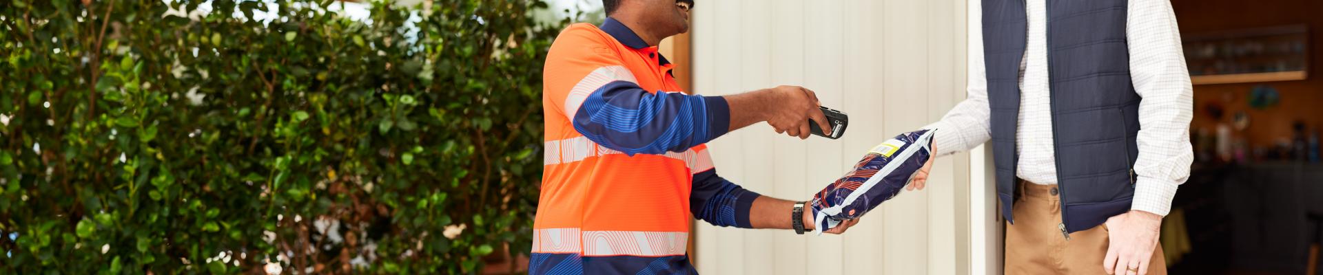 Parcel being scanned on delivery by a man in a high vis shirt