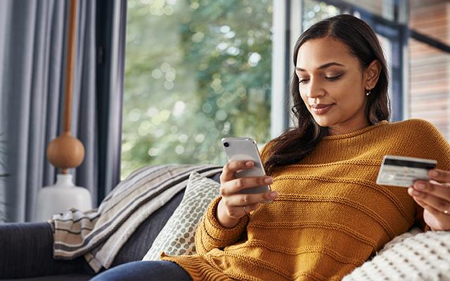 Woman holding credit card and phone