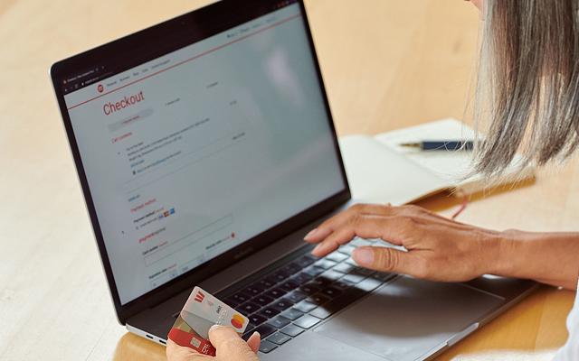 Woman shopping on laptop, holding credit card