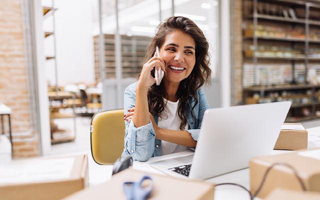 woman talking on her mobile in front of computer